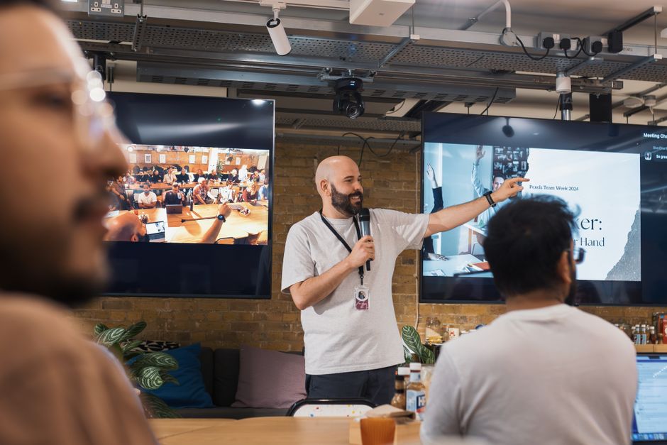 Team leader delivering a presentation in a lively office environment. Dynamic and collaborative setting.